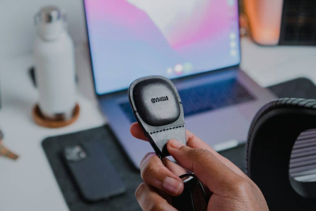 a person holding a cell phone in front of a laptop